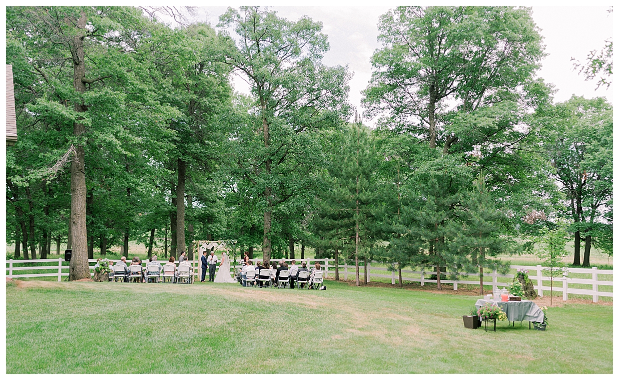first kiss as husband and wife, Minnesota backyard wedding with floral arch, Little Falls Wedding